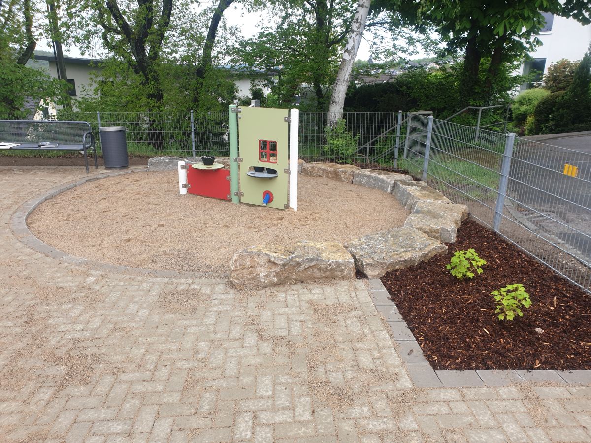 Spielplatz mit Spielgeräten und Fallschutzflächen